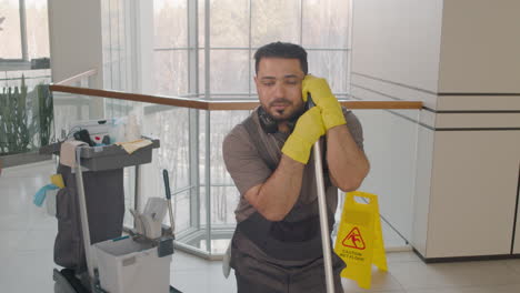 Arabic-Cleaning-Man-Posing-At-Camera-While-Holding-A-Mop-Stick