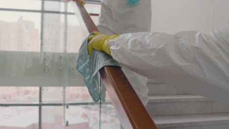 Nahaufnahme-Der-Reinigung-Von-Mannhänden-Mit-Handschuhen,-Die-Treppengeländer-In-Einem-Bürogebäude-Reinigen