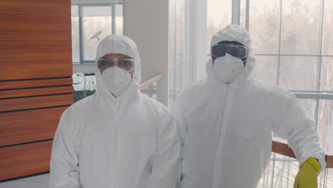 Two-Cleaning-Men-Wearing-Personal-Protective-Equipment-Looking-At-Camera-Inside-An-Office-Building
