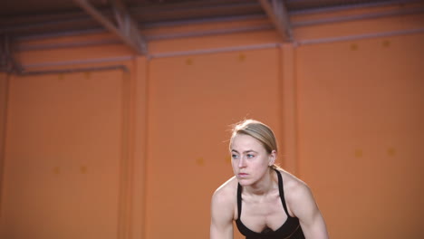 Blonde-Sportswoman-Warming-Up-And-Stretching-Her-Body-In-Indoor-Sport-Facility