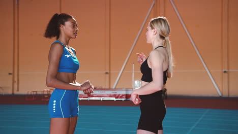 Two-Multiethnic-Sportswomen-Talking-Together-In-An-Indoor-Sport-Facility-During-Training-Session