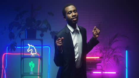 American-Young-Man-In-Fancy-Suit-Dancing-In-Room-With-Neon-Lights