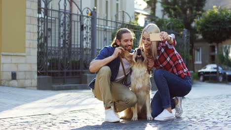 Junges-Paar,-Das-An-Einem-Sonnigen-Tag-Ein-Selfie-Mit-Einem-Labrador-Hund-Mit-Smartphone-Auf-Der-Straße-Macht