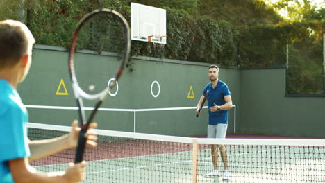 Rückansicht-Eines-Teenagers,-Der-An-Einem-Sonnigen-Tag-Mit-Seinem-Vater-Tennis-Spielt