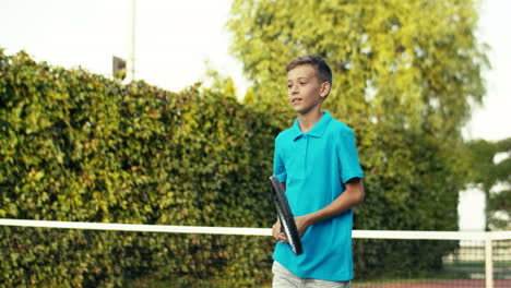 Teen-Boy-With-Racket-Training-On-Outdoor-Tennis-Court-On-A-Summer-Day-1