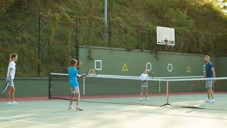 Glückliche-Familie,-Die-Im-Sommer-Auf-Einem-Außenplatz-Tennis-Spielt-2