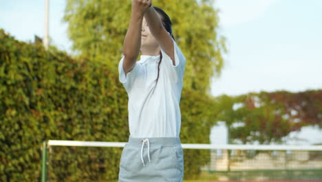 Cute-Little-Girl-Training-With-Racket-On-An-Outdoor-Tennis-Court-In-Summer