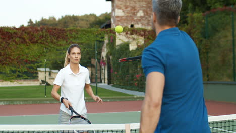 Glückliches-Paar,-Das-An-Einem-Sommertag-Zusammen-Auf-Dem-Außenplatz-Tennis-Spielt