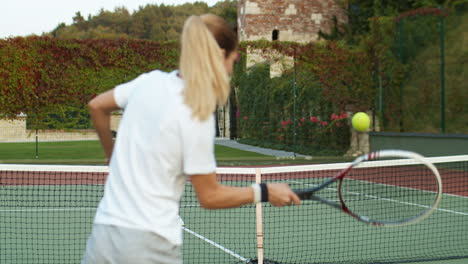 Rückansicht-Einer-Sportlichen-Frau,-Die-An-Einem-Sommertag-Mit-Einem-Mann-Auf-Dem-Außenplatz-Tennis-Spielt