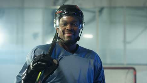 Retrato-De-Un-Jugador-De-Hockey-Masculino-Feliz-Mirando-La-Cámara-En-La-Arena-De-Hielo