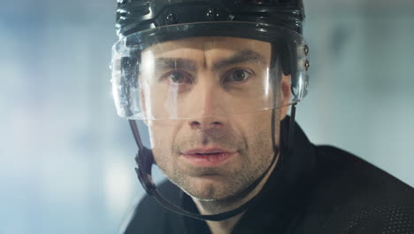Close-Up-Of-A-Concentrated-Male-Hockey-Player-Looking-At-The-Camera-And-Breathing-In-Cold-Air-On-The-Ice-Arena