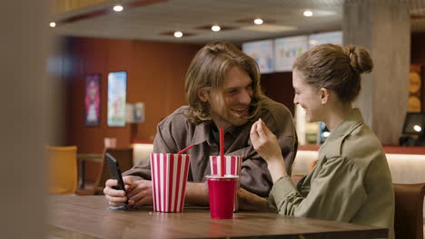 Glückliches-Paar,-Das-Zusammen-Spaß-Hat,-Während-Es-Popcorn-An-Der-Kino-snackbar-Isst