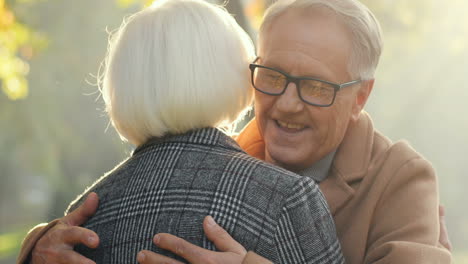 Close-Up-View-Of-Elderly-Married-Couple-Hugging-Each-Other-In-The-Park-At-Sunset-In-Autumn