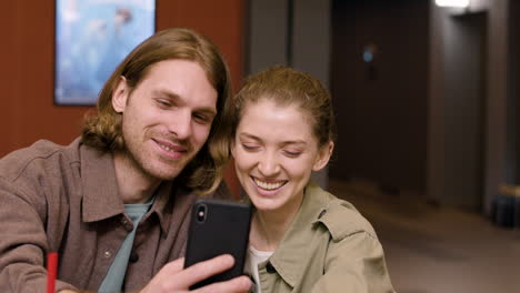 Glückliches-Paar,-Das-Spaß-Hat,-Während-Es-Ein-Selfie-Mit-Dem-Telefon-Im-Kino-Macht