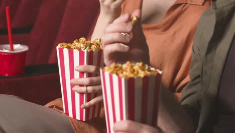 Nahaufnahme-Von-Paarhänden,-Die-Popcorn-Im-Kino-Halten-1