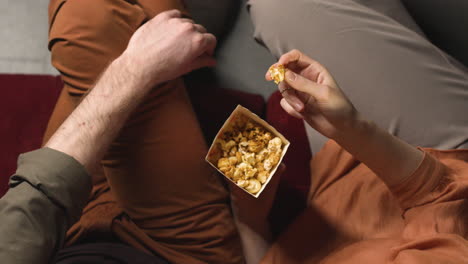 Top-View-Of-Couple-Eating-Popcorn-While-They-Watching-A-Movie-In-The-Cinema