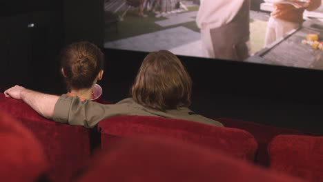 Rear-View-Of-Couple-Hugging-Sitting-In-The-Cinema-While-They-Watching-A-Movie-And-Talking-2