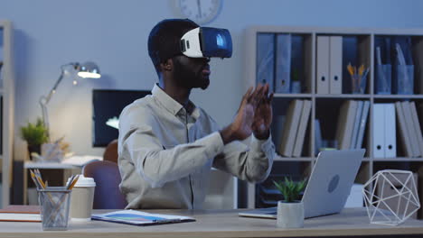 Young-Office-Worker-Wearing-A-Vr-Headset,-Scrolling-And-Taping-In-The-Air-In-The-Office-At-Night