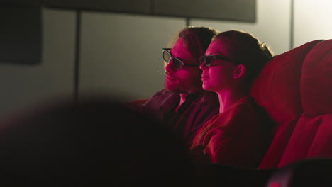 Seitenansicht-Eines-Paares-Mit-3D-Brille,-Das-Im-Kino-Sitzt,-Während-Es-Sich-Einen-Film-Ansieht-Und-Bei-Ausgeschaltetem-Licht-Popcorn-Isst-1