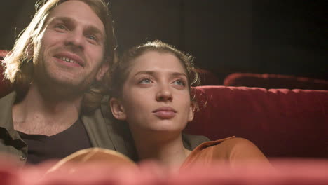 Close-Up-View-Of-Couple-Sitting-In-The-Cinema-Watching-A-Movie-And-Smiling