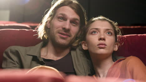 Close-Up-View-Of-Couple-Sitting-In-The-Cinema-Watching-A-Movie-And-Talking