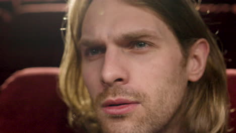 Close-Up-View-Of-Blond-Man-Watching-A-Movie-In-The-Cinema