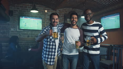 Tres-Hombres-Sonrientes-Multiétnicos-De-Pie-Y-Posando-Para-La-Cámara-Con-Cerveza-En-Las-Manos