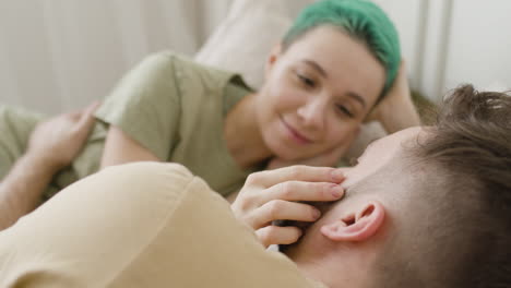 Loving-Woman-Touching-Her-Boyfriend's-Face-While-Relaxing-On-The-Bed-And-Looking-At-Each-Other-1