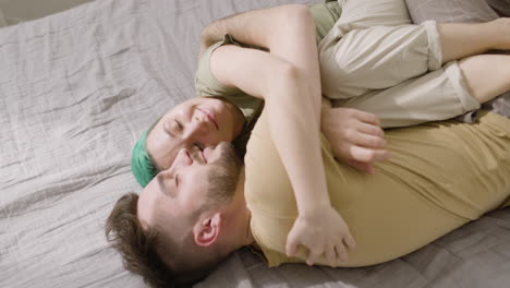 Top-View-Of-A-Loving-Couple-Hugging-And-Cuddling-While-Lying-On-The-Bed