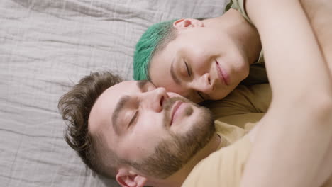 Happy-Couple-Sleeping-Face-To-Face-On-The-Bed