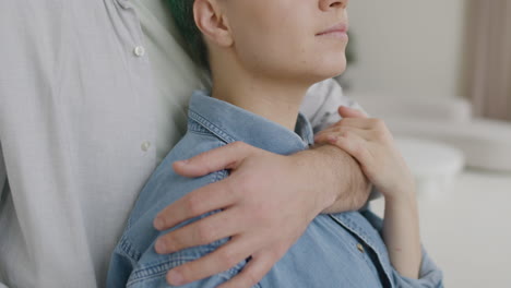 Close-Up-Of-A-Handsome-Man-Tenderly-Hugging-His-Girlfriend-From-The-Back-At-Home
