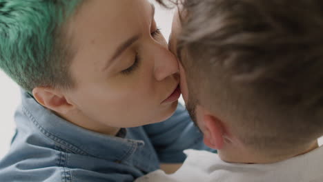 Close-Up-Of-Loving-Woman-Tenderly-Cuddling-And-Kissing-Her-Boyfriend-At-Home