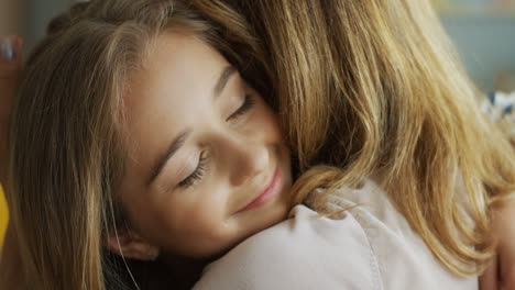 Close-Up-Of-Teen-Girl-Hugging-Her-Mother-And-Smiling
