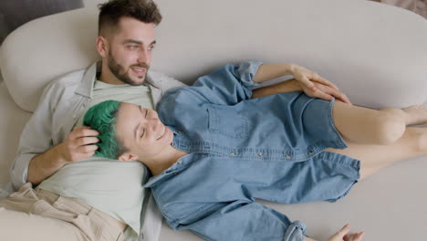 Top-View-Of-Young-Couple-Sitting-On-Sofa,-Talking-And-Caressing-Each-Other