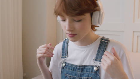 Close-Up-View-Of-Girl-Sitting-On-Bed-Wearing-Headphones-And-Moving-Her-Head-To-The-Beat-Of-The-Music