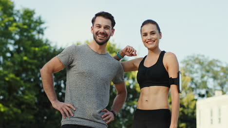 Young-Jogger-Couple-Talking-And-Smiling-To-The-Camera-After-Sport-And-Jogging-In-The-Stadium