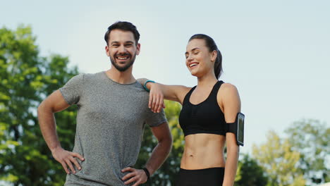 Young-Jogger-Couple-Posing-Outdoor-And-Smiling-To-The-Camera