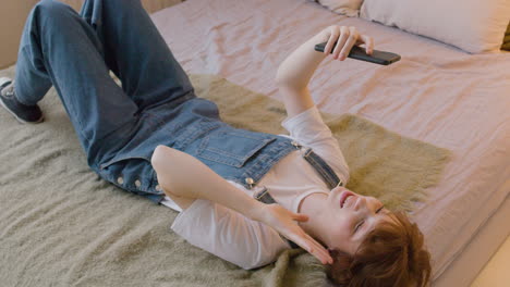 Girl-Lying-On-The-Bed-And-Having-A-Video-Call-Using-Smartphone-In-The-Bedroom