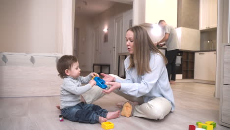 Baby-Playing-Sitting-On-The-Floor-With-Toys-And-With-His-Mother
