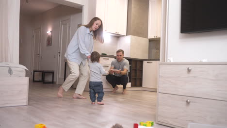 Mother-Helping-Her-Baby-To-Take-His-First-Steps-To-The-Kitchen