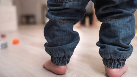 Rear-View-Of-A-Barefoot-Baby-Taking-His-First-Steps