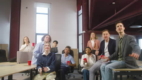 Group-Of-Multiethnic-Colleagues-Watching-A-Sportive-Match,-Cheering-And-Supporting-Their-Team-At-The-Office-1
