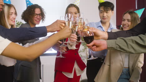 Multiethnic-Colleagues-With-Party-Hat-Toasting-And-Drinking-At-The-Office-Party-1