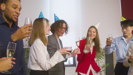 Multiethnic-Colleagues-With-Party-Hat-Toasting-And-Drinking-At-The-Office-Party-3