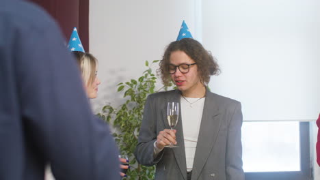 Happy-Boy-And-Girl-With-Party-Hat-Drinking-And-Talking-Together-At-The-Office-Party-1