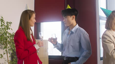 Mann-Und-Frau,-Die-Champagnerglas-Halten-Und-Auf-Der-Büroparty-Miteinander-Sprechen