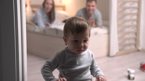Parents-Lying-On-The-Bed-And-Their-Son-Is-Standing-On-The-Floor-Of-The-Room