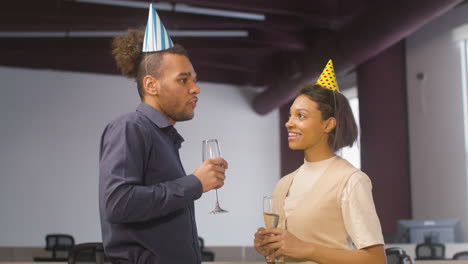 American-Woman-And-Man-Talking-Together,-Then-Toasting-And-Drinking-Champagne-At-The-Office-Party
