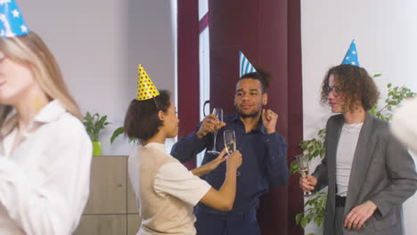 Gruppe-Multiethnischer-Kollegen,-Die-Champagnerglas-Halten,-Tanzen-Und-Gemeinsam-Spaß-Auf-Der-Büroparty-Haben