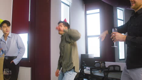 Excited-Young-Man-Dancing-And-Having-Fun-With-Colleagues-At-The-Office-Party